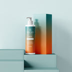 Skin Win Essentials Enriching Body Oil bottle and matching gift box on a teal-to-orange display