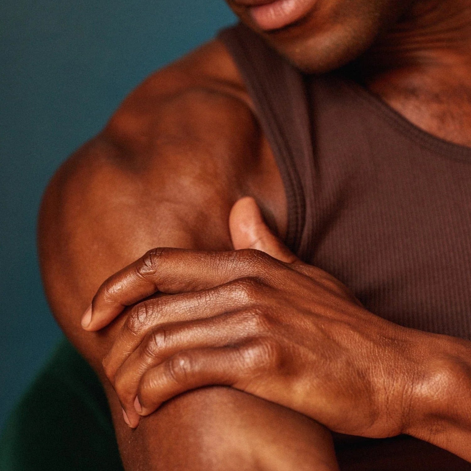 Man with a muscular arm and shoulder against a blue background